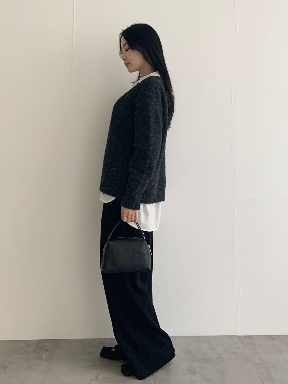 グレー系のニット/セーター、ホワイト系のシャツ/ブラウス、ブラック系のその他パンツを着用したレディースの秋コーディネートの4枚目の写真