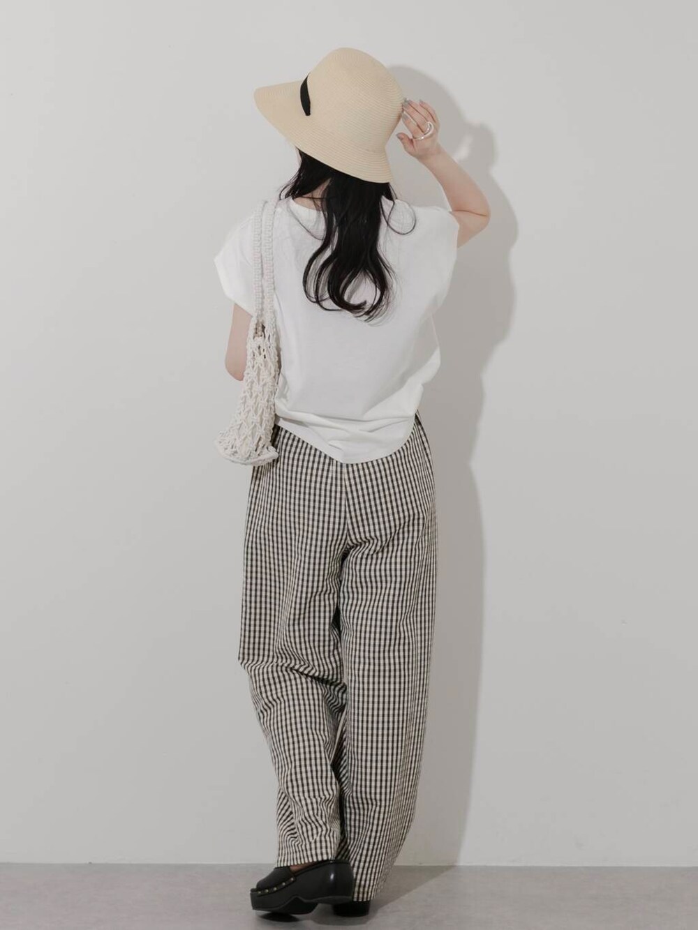 ホワイト系のTシャツ/カットソー、ホワイト系のハンドバッグ、ブラック系のサンダルを着用したレディースの春コーディネートの4枚目の写真