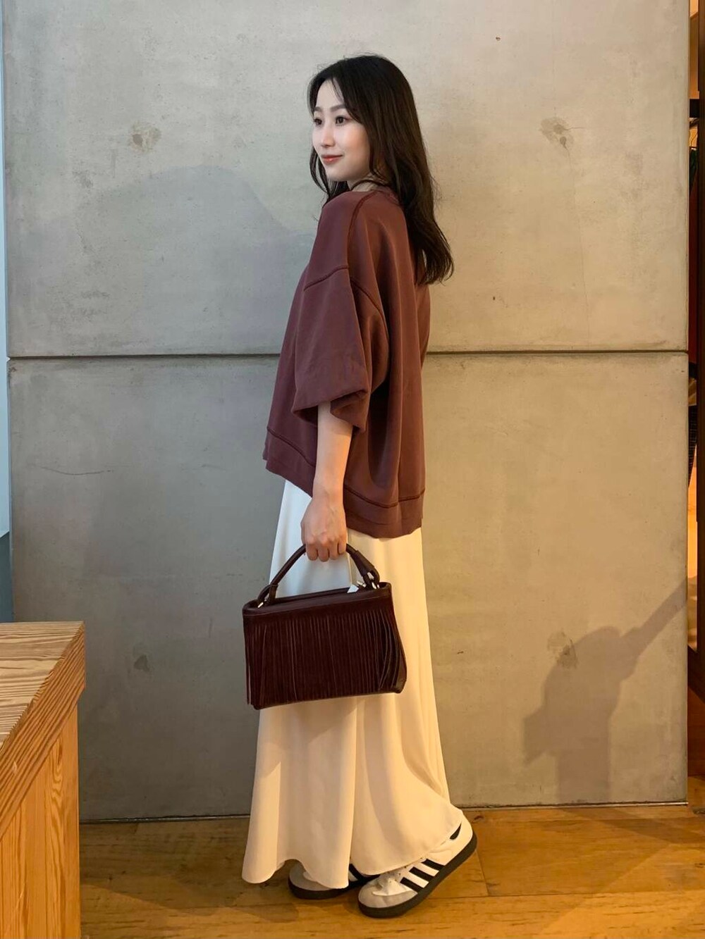 ホワイト系のスカート、ホワイト系のスニーカー、ブラウン系のTシャツ/カットソーを着用したレディースの夏コーディネートの4枚目の写真