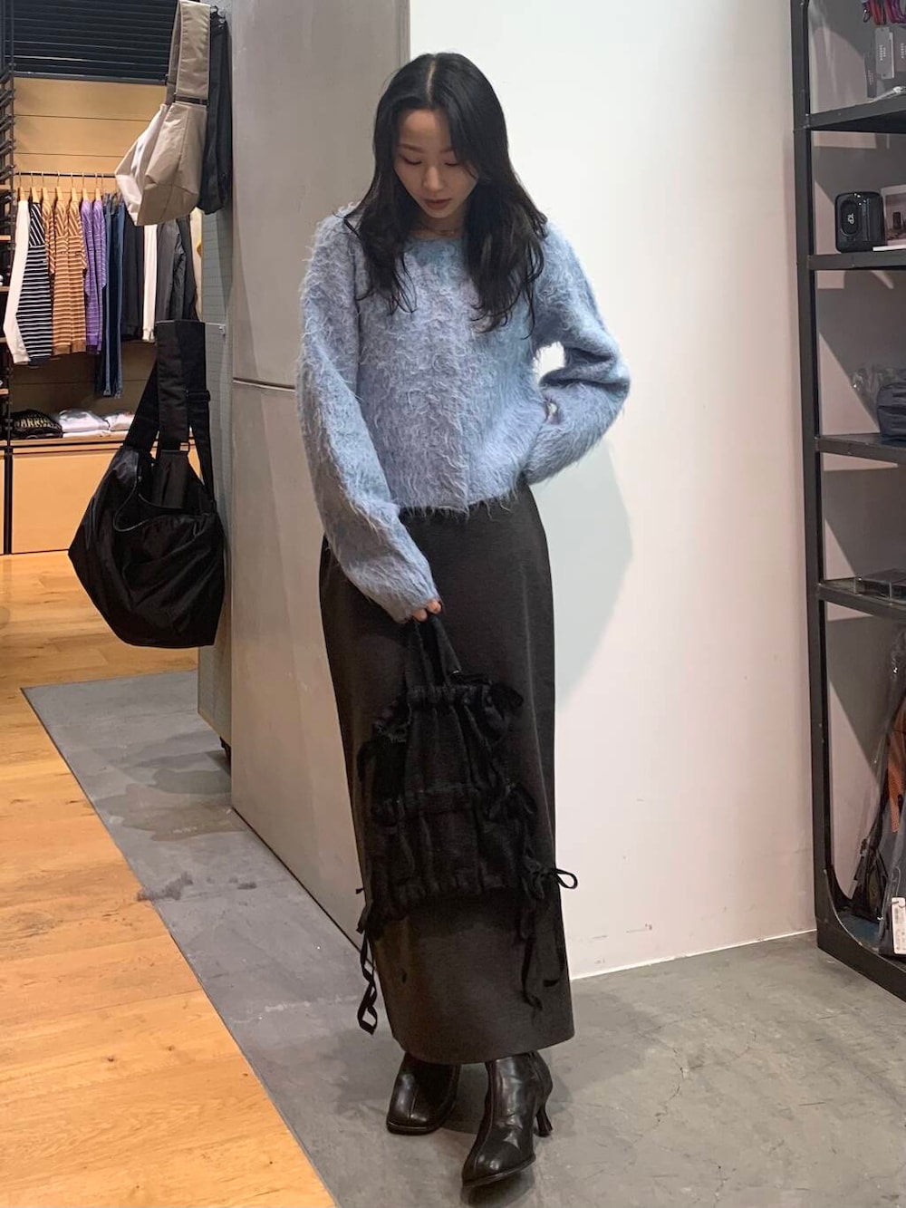 ブラック系のブーツ、グレー系のスカート、ブルー系のカーディガン/ボレロを着用したレディースの冬コーディネートの3枚目の写真