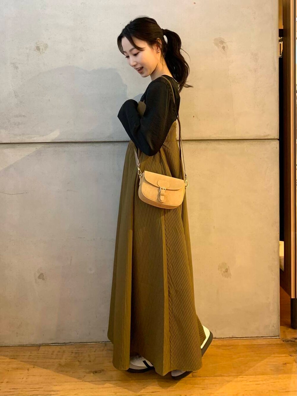 ベージュ系のショルダーバッグ、ホワイト系のスニーカー、ブラウン系のワンピースを着用したレディースの夏コーディネートの5枚目の写真