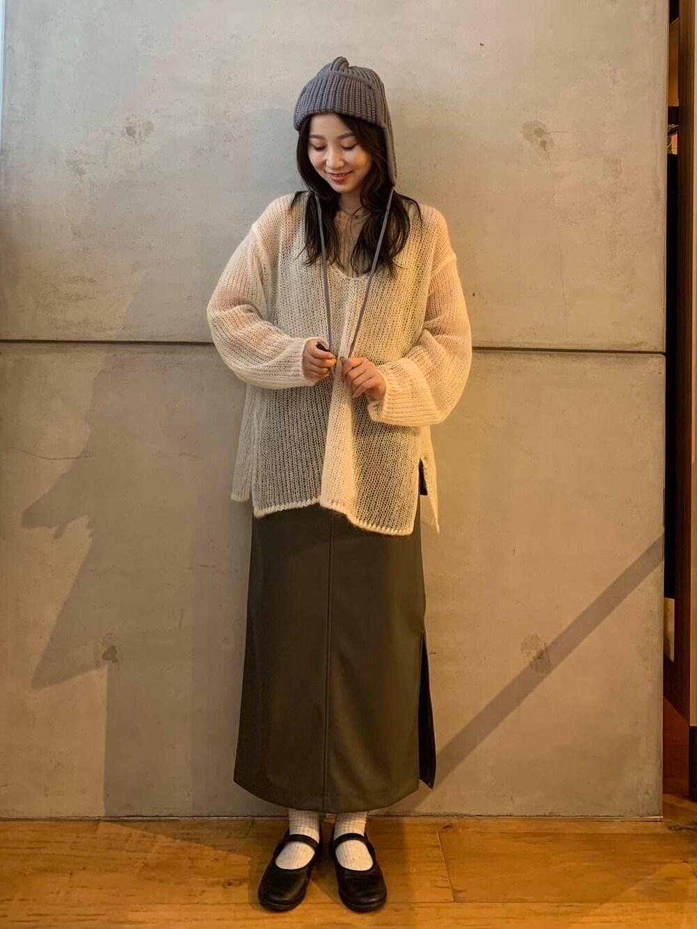 ベージュ系のタンクトップ、グレー系のスカート、ホワイト系のニット/セーターを着用したレディースの秋コーディネートの3枚目の写真