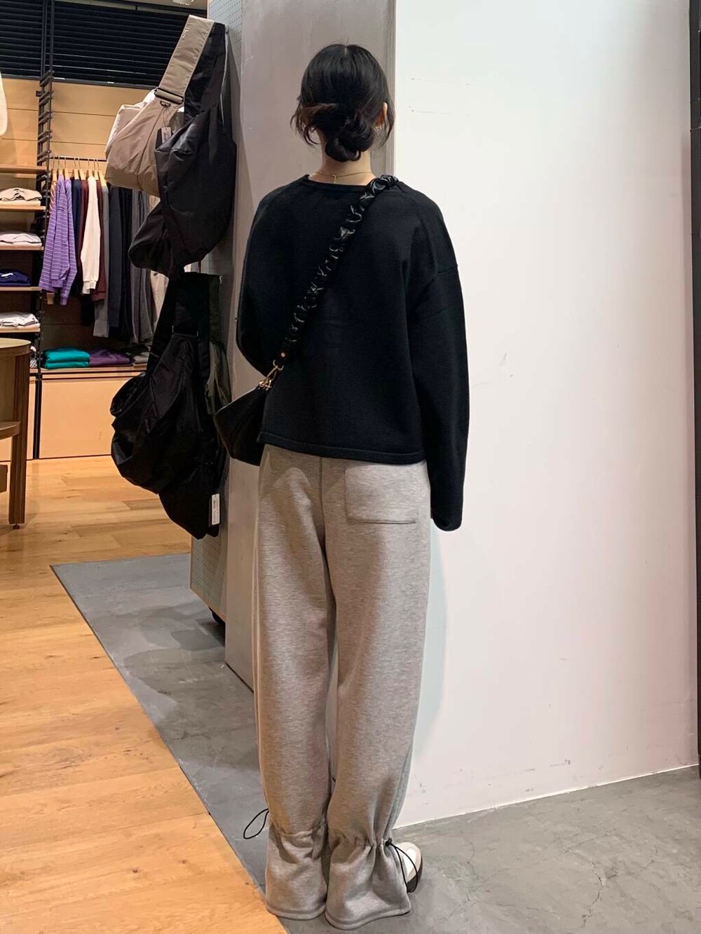 ホワイト系のスニーカー、ブラック系のカーディガン/ボレロ、ブラック系のショルダーバッグを着用したレディースの冬コーディネートの5枚目の写真