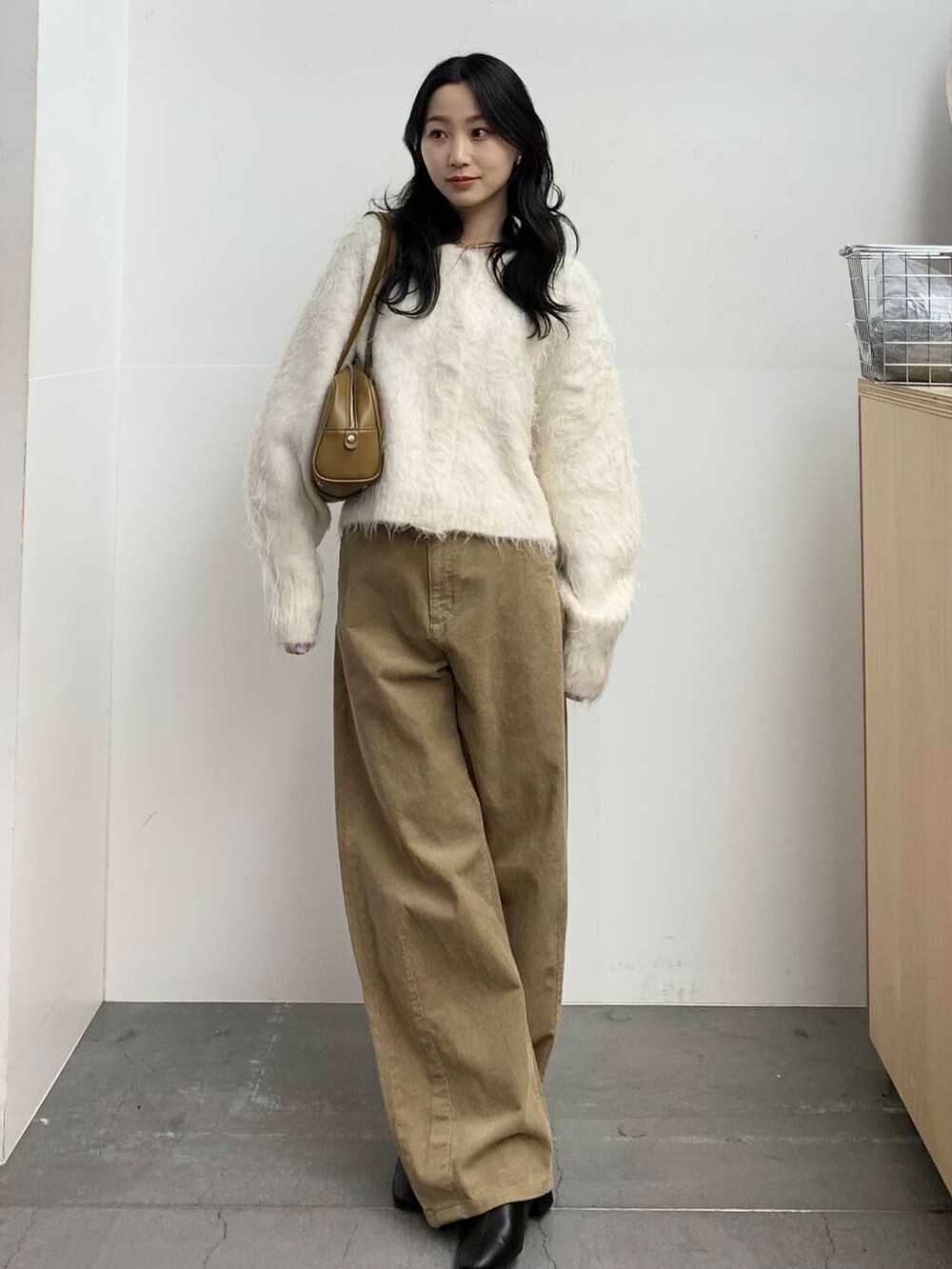 ブラック系のブーツ、グリーン系のボストンバッグ、ベージュ系のその他パンツを着用したレディースの冬コーディネートの4枚目の写真