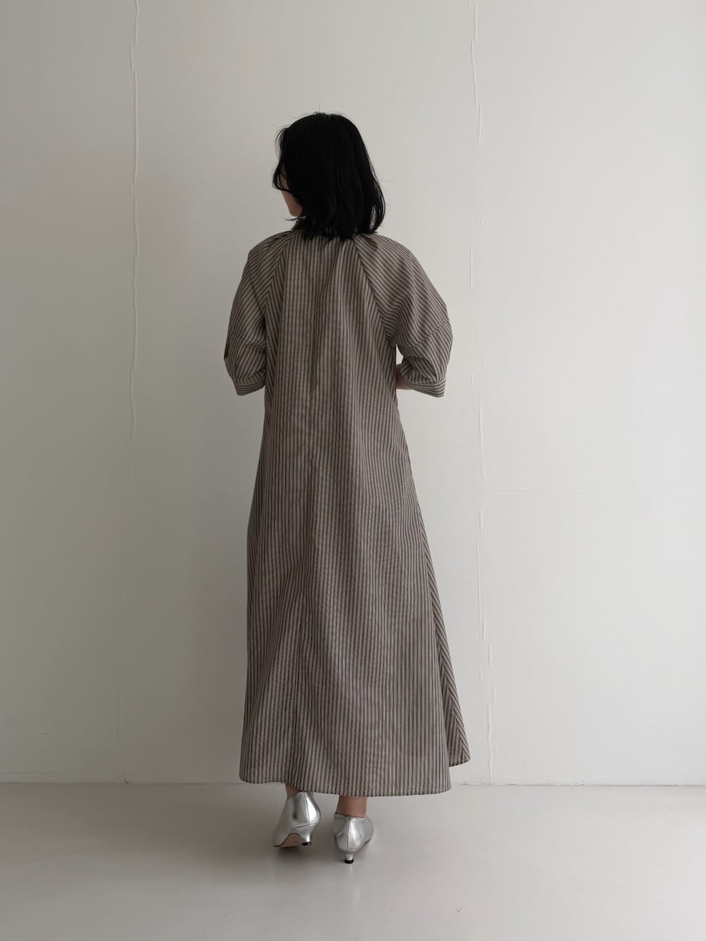 ブラウン系のワンピース、シルバー系のパンプスを着用したレディースの春コーディネートの6枚目の写真