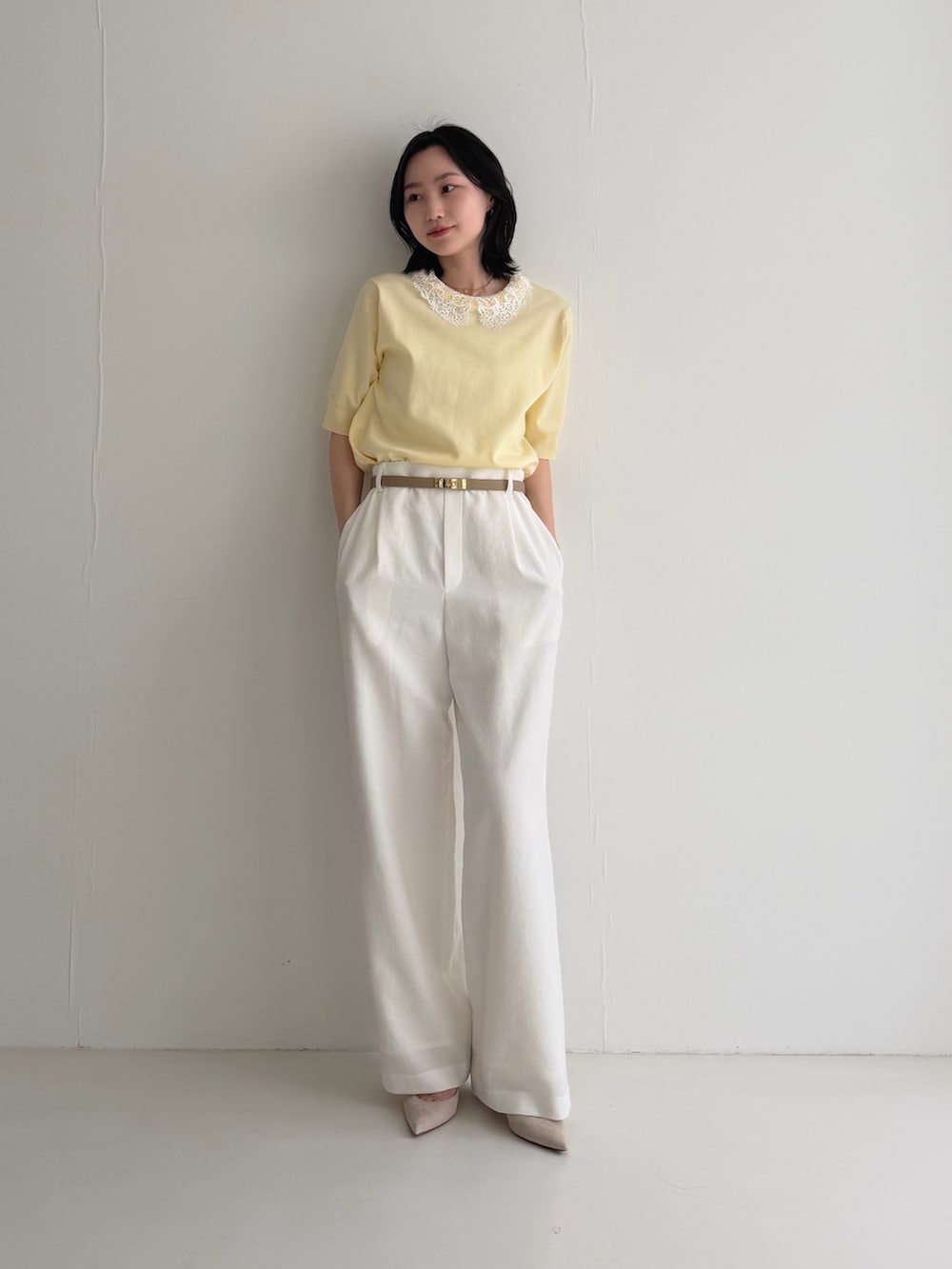 イエロー系のニット/セーター、ベージュ系のパンプス、ベージュ系のベルトを着用したレディースの春コーディネートの2枚目の写真