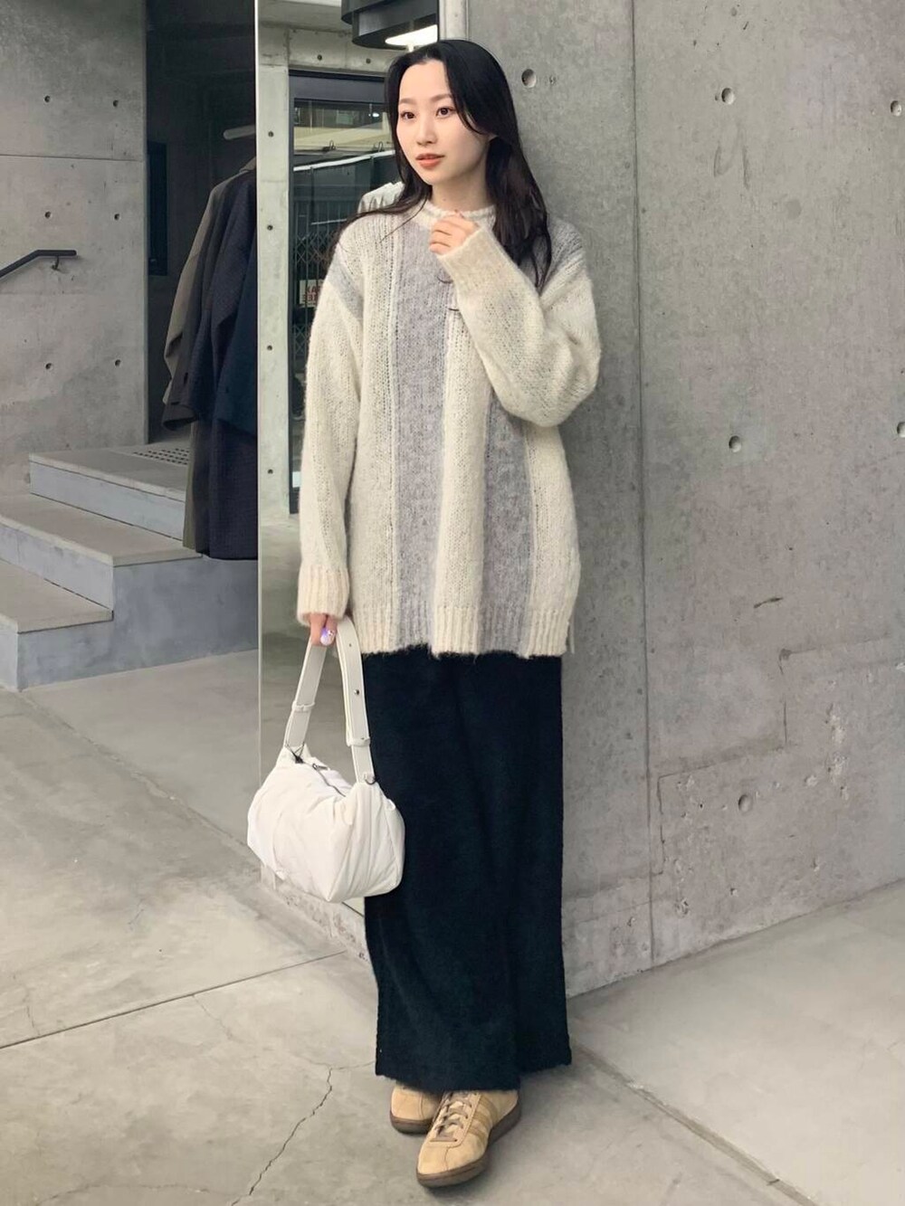 ブラック系のその他パンツ、グリーン系のニット/セーター、ホワイト系のショルダーバッグを着用したレディースの冬コーディネートの3枚目の写真