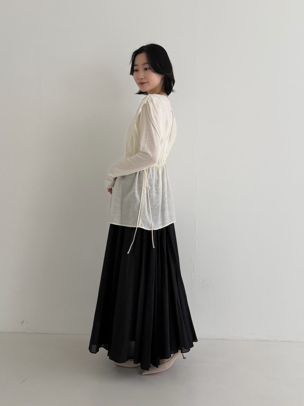 ブラック系のスカート、ホワイト系のその他トップス、ホワイト系のTシャツ/カットソーを着用したレディースの冬コーディネートの3枚目の写真