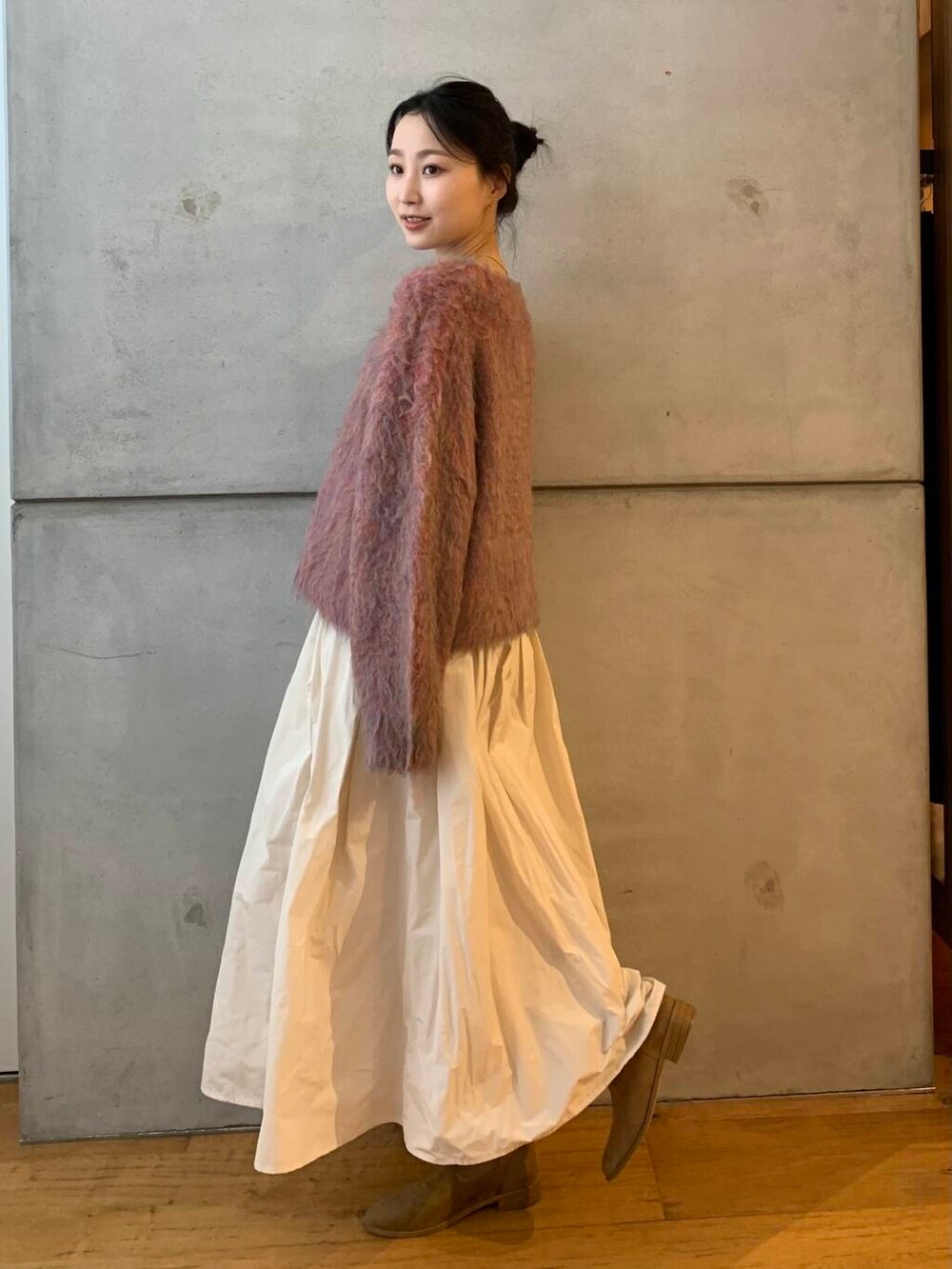 ピンク系のニット/セーター、ホワイト系のスカートを着用したレディースの秋コーディネートの6枚目の写真