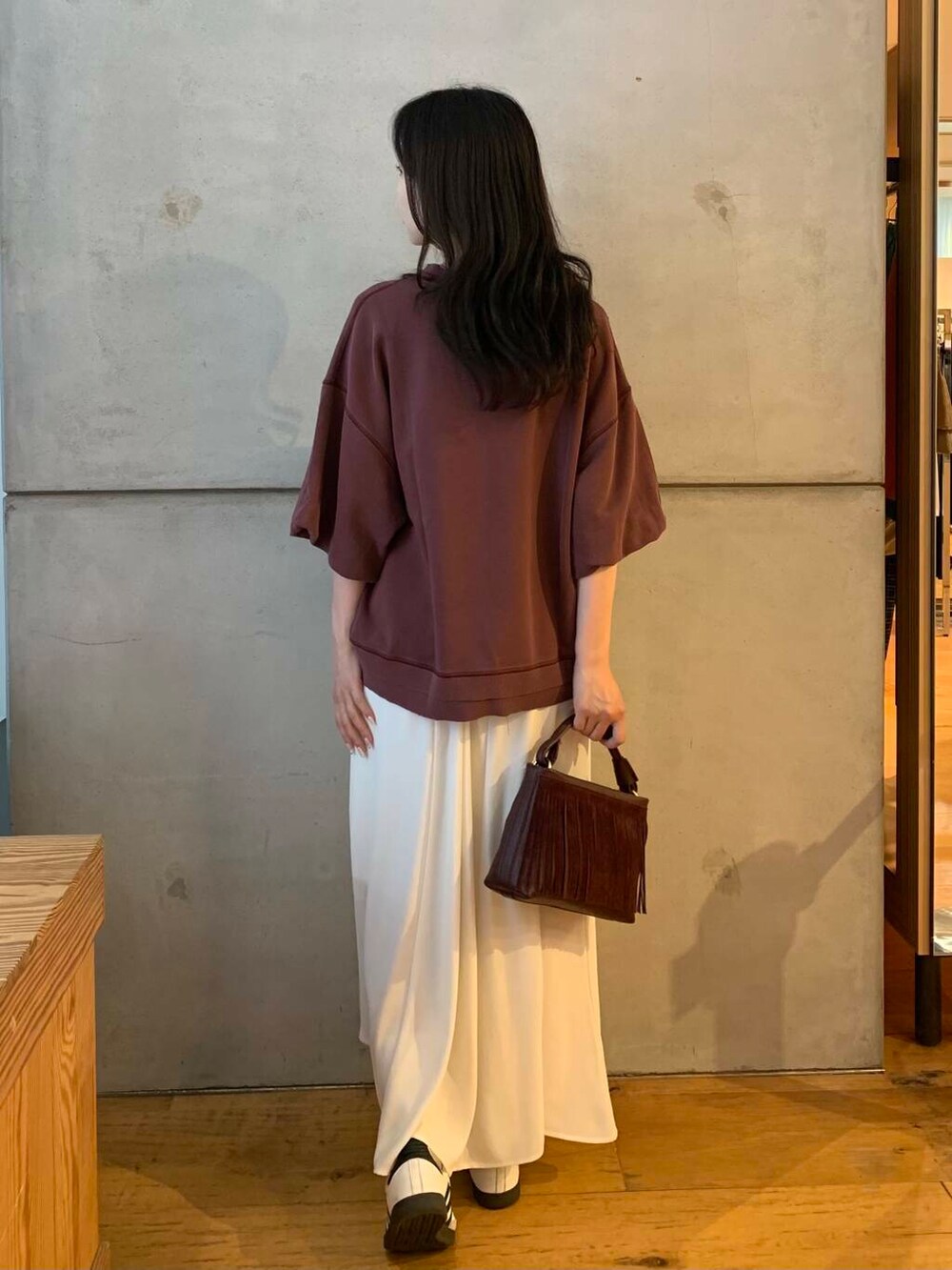 ホワイト系のスカート、ホワイト系のスニーカー、ブラウン系のTシャツ/カットソーを着用したレディースの夏コーディネートの5枚目の写真