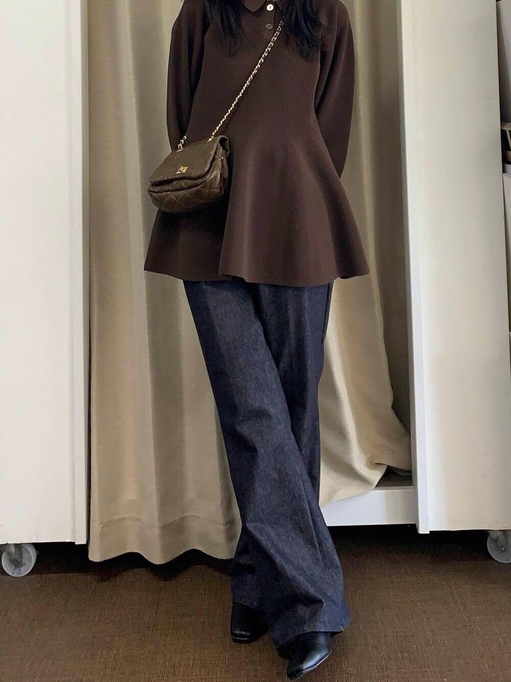 ブラウン系のショルダーバッグ、ブルー系のデニムパンツ、ブラウン系のニット/セーターを着用したレディースの秋コーディネートの2枚目の写真