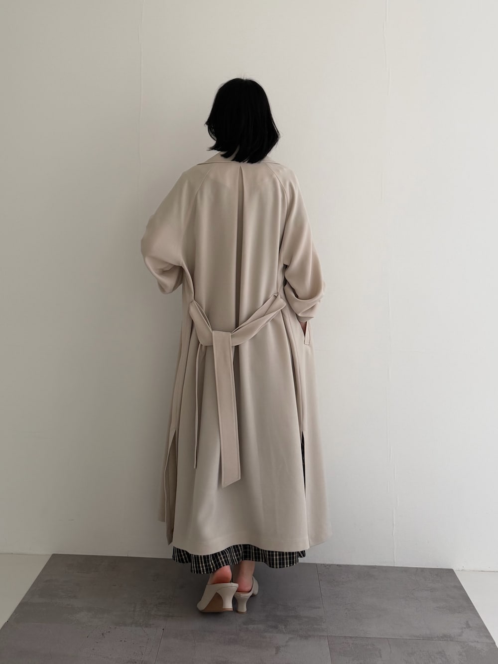 ブラウン系のワンピース、ベージュ系のトレンチコートを着用したレディースの春コーディネートの4枚目の写真