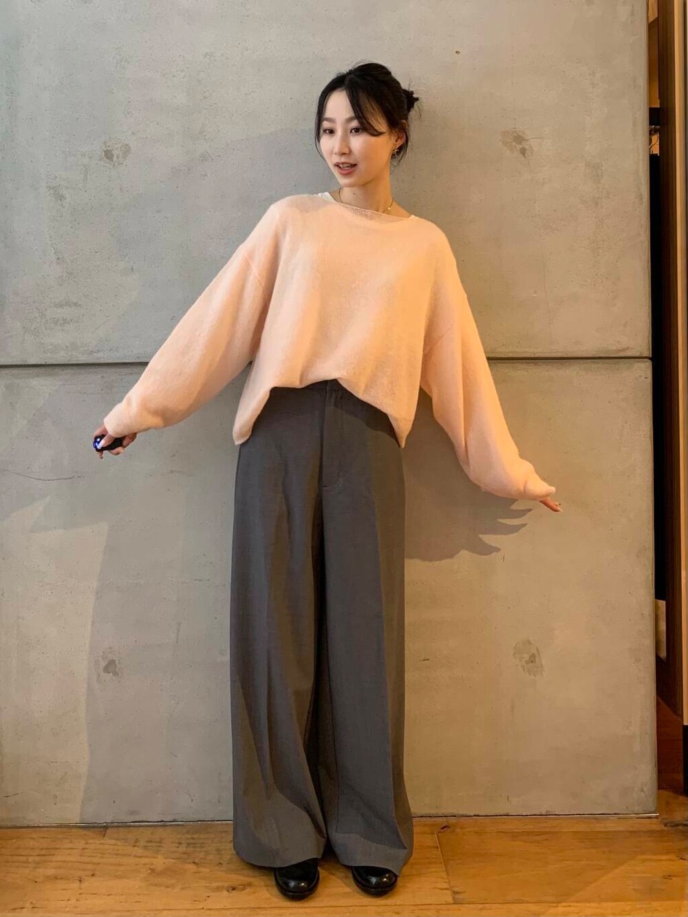 グレー系のその他パンツ、ブラック系のレインシューズ、ピンク系のニット/セーターを着用したレディースの秋コーディネートの2枚目の写真