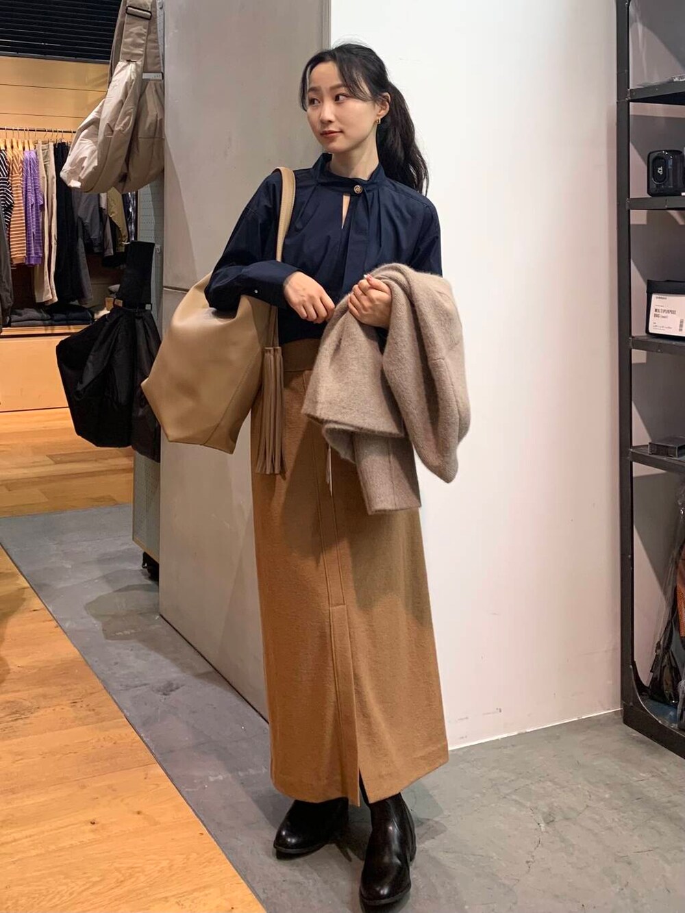 ブラック系のブーツ、ブラウン系のカーディガン/ボレロ、ベージュ系のトートバッグを着用したレディースの秋コーディネートの4枚目の写真