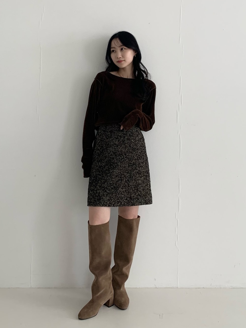 ブラウン系のTシャツ/カットソー、ベージュ系のスカート、ブラウン系のブーツを着用したレディースの秋コーディネートの2枚目の写真