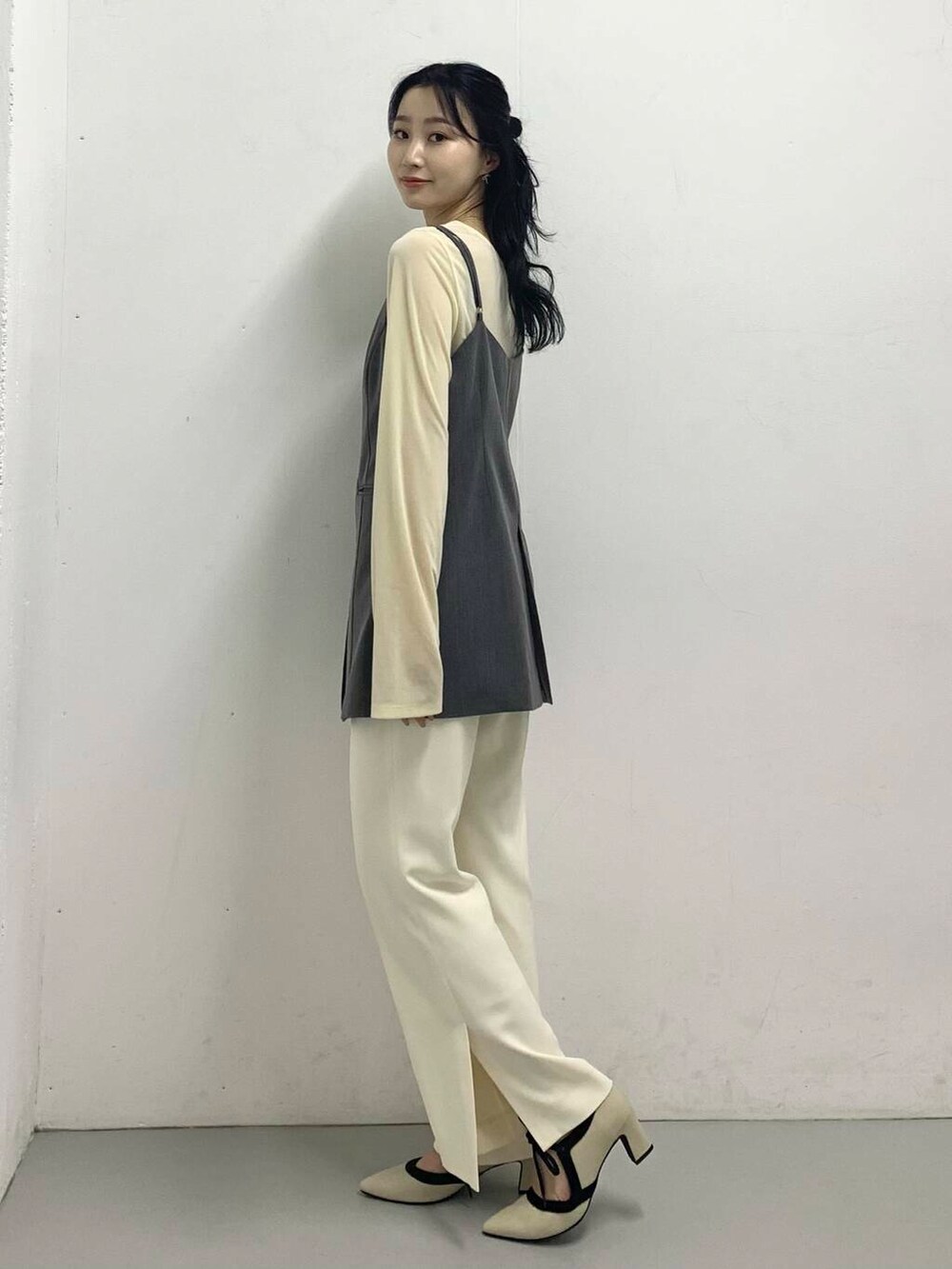 グレー系のチュニック、ホワイト系のパンプス、ホワイト系のTシャツ/カットソーを着用したレディースの秋コーディネートの4枚目の写真