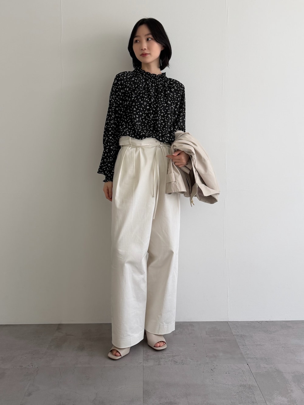 ブラック系のシャツ/ブラウス、ホワイト系のその他パンツ、ベージュ系のその他アウターを着用したレディースの冬コーディネートの2枚目の写真