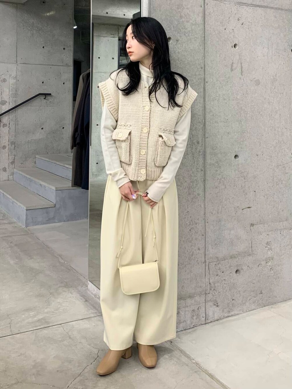 ベージュ系のブーツ、ホワイト系のその他パンツ、ホワイト系のベストを着用したレディースの冬コーディネートの2枚目の写真