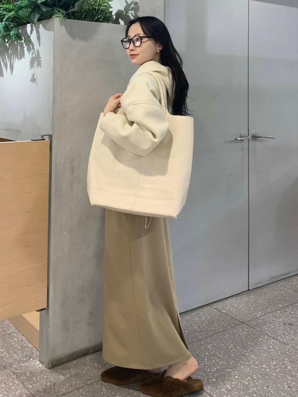 イエロー系のその他シューズ、ベージュ系のスカート、ホワイト系のパーカーを着用したレディースの冬コーディネートの5枚目の写真