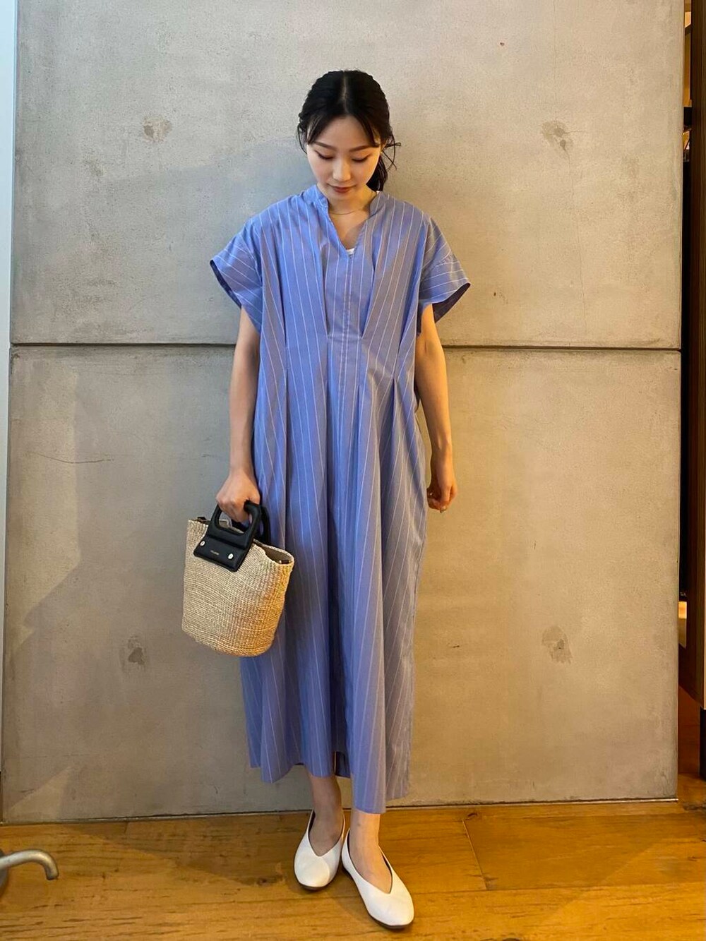 ベージュ系のハンドバッグ、ホワイト系のパンプス、ブルー系のワンピースを着用したレディースの夏コーディネートの3枚目の写真