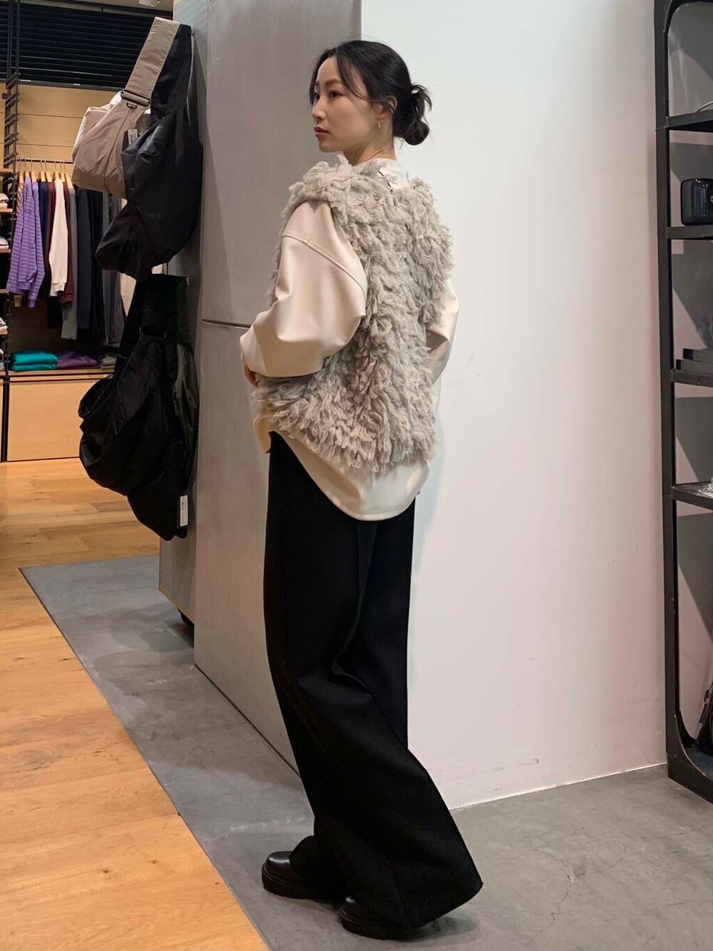 ブラック系のブーツ、グレー系のスウェット、グレー系のベストを着用したレディースの冬コーディネートの5枚目の写真