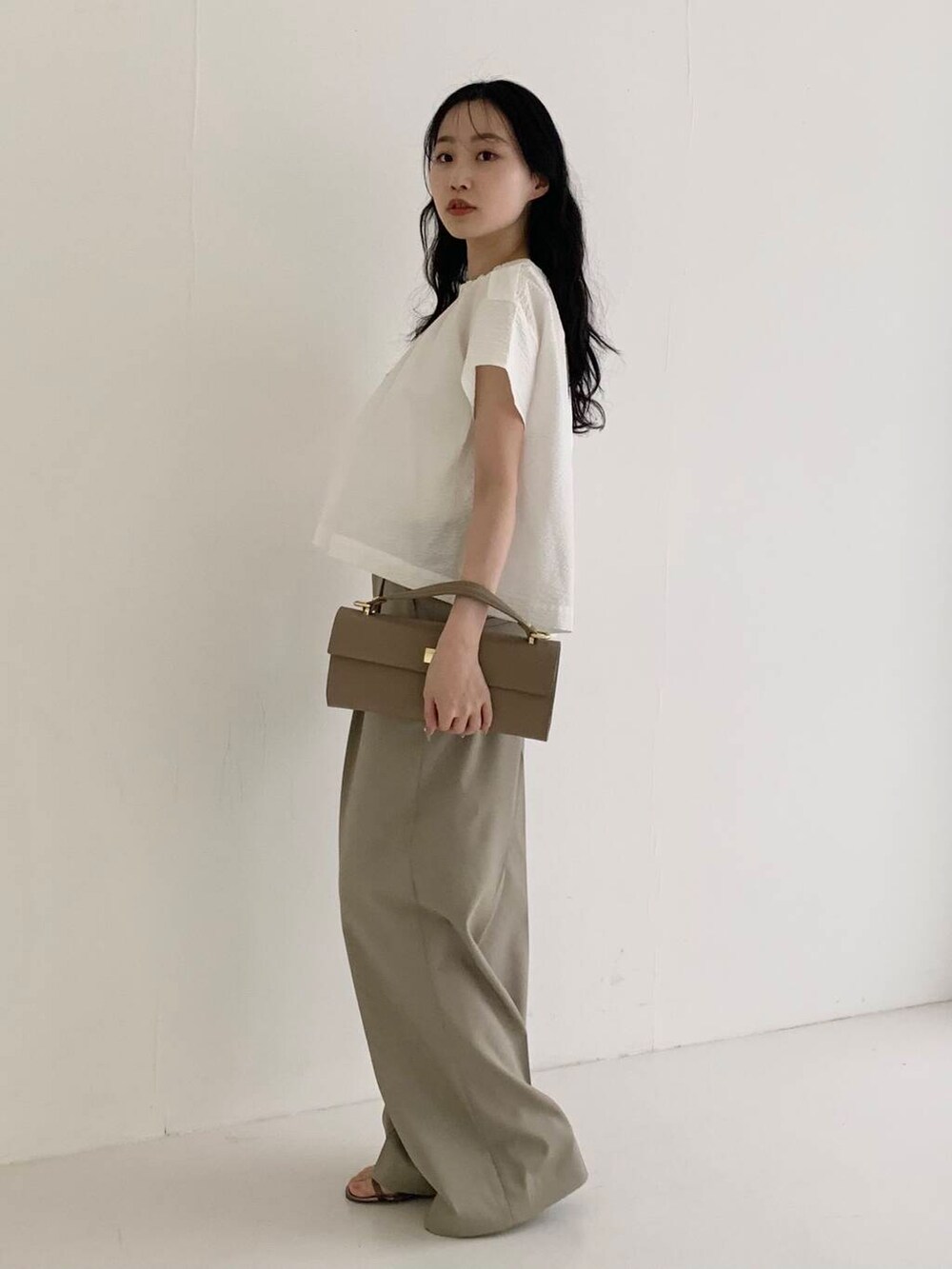 ベージュ系のショルダーバッグ、ブラウン系のその他パンツ、ホワイト系のシャツ/ブラウスを着用したレディースの春コーディネートの2枚目の写真