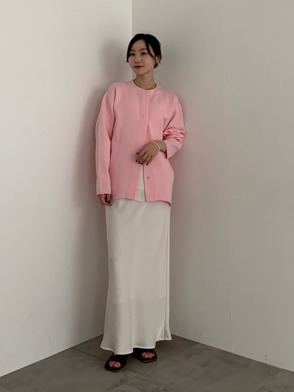 ピンク系のカーディガン/ボレロ、ホワイト系のスカートを着用したレディースの春コーディネートの2枚目の写真