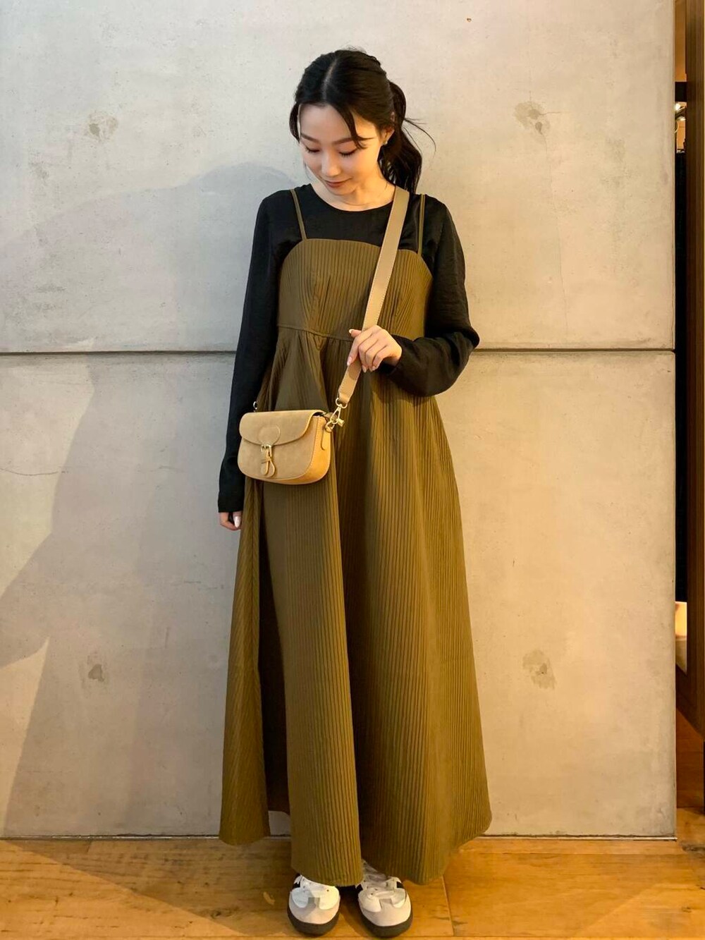 ベージュ系のショルダーバッグ、ホワイト系のスニーカー、ブラウン系のワンピースを着用したレディースの夏コーディネートの3枚目の写真