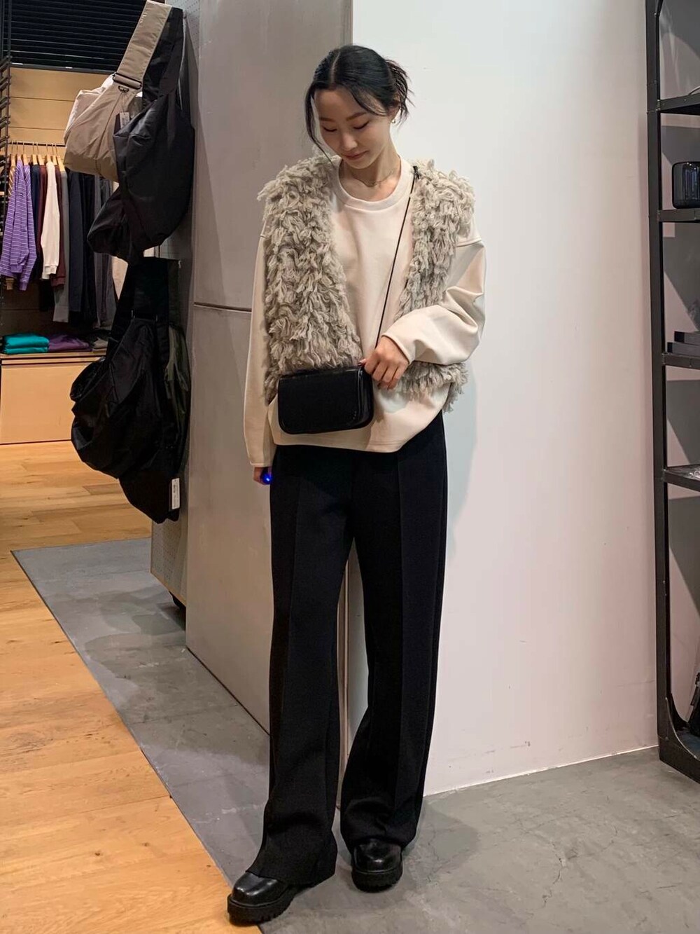 ブラック系のブーツ、グレー系のスウェット、グレー系のベストを着用したレディースの冬コーディネートの4枚目の写真