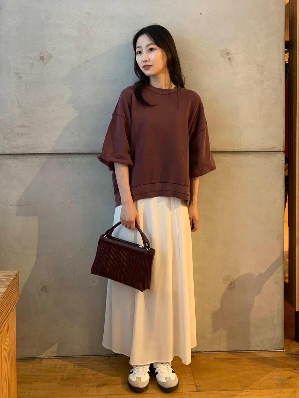 ホワイト系のスカート、ホワイト系のスニーカー、ブラウン系のTシャツ/カットソーを着用したレディースの夏コーディネートの3枚目の写真