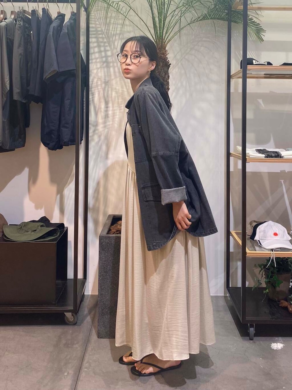 グリーン系のワンピース、ブラック系のサンダル、ブルー系のタンクトップを着用したレディースの夏コーディネートの4枚目の写真