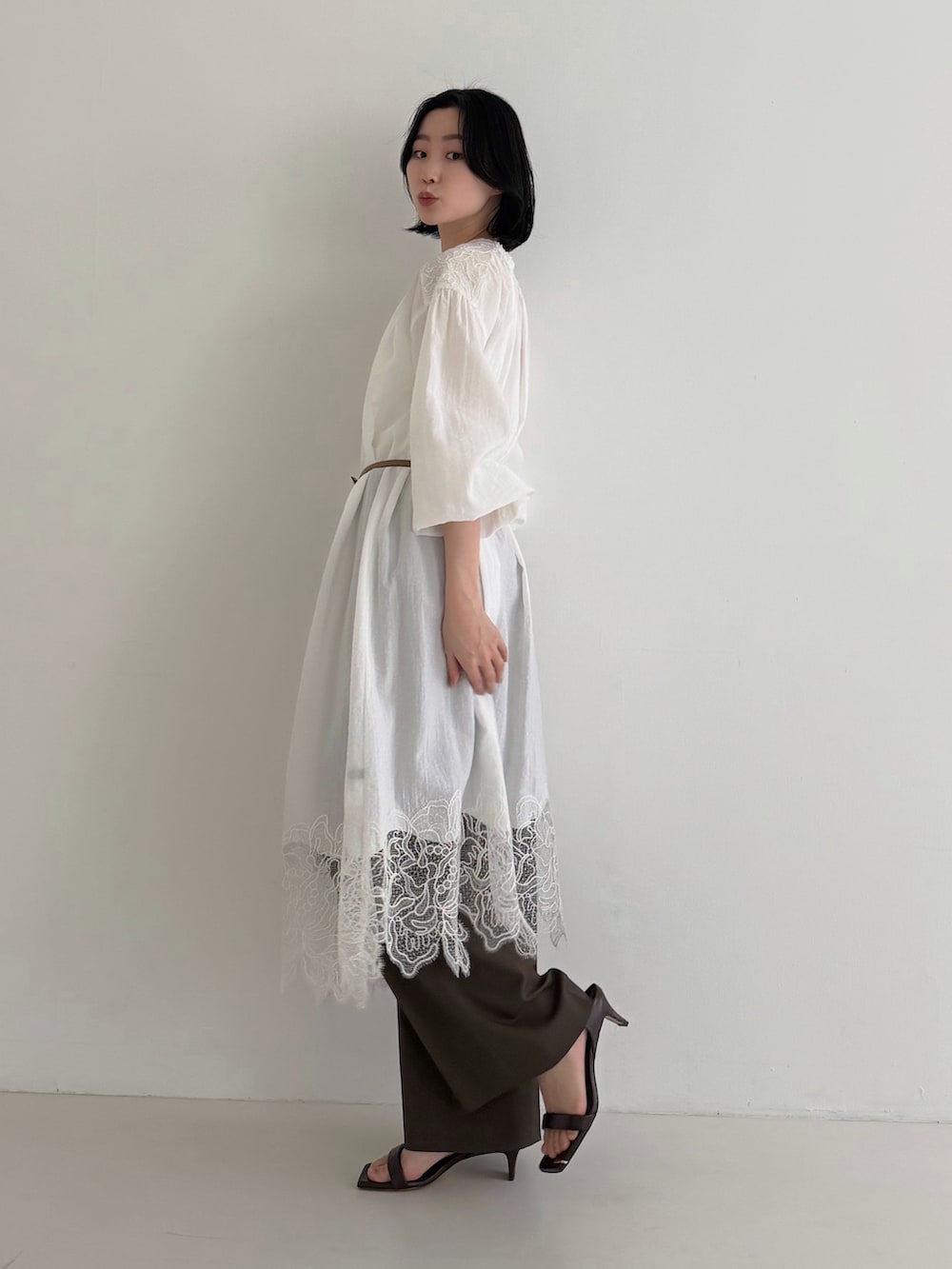 ホワイト系のワンピース、ブラウン系のその他パンツを着用したレディースの冬コーディネートの2枚目の写真