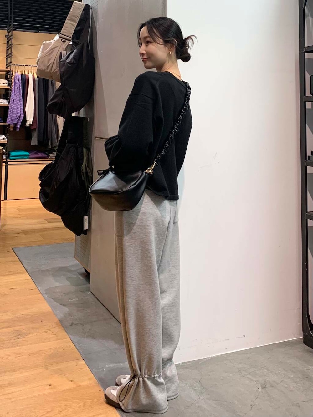 ホワイト系のスニーカー、ブラック系のカーディガン/ボレロ、ブラック系のショルダーバッグを着用したレディースの冬コーディネートの4枚目の写真