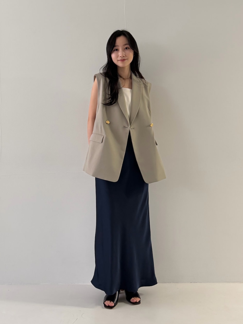 ベージュ系のベスト、ブルー系のスカートを着用したレディースの冬コーディネートの3枚目の写真