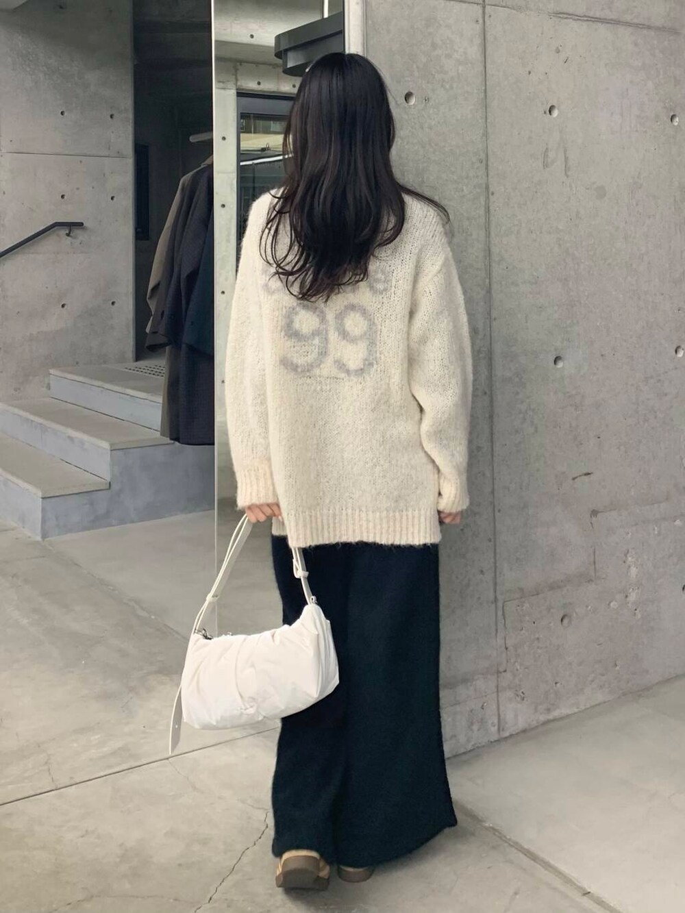 ブラック系のその他パンツ、グリーン系のニット/セーター、ホワイト系のショルダーバッグを着用したレディースの冬コーディネートの7枚目の写真