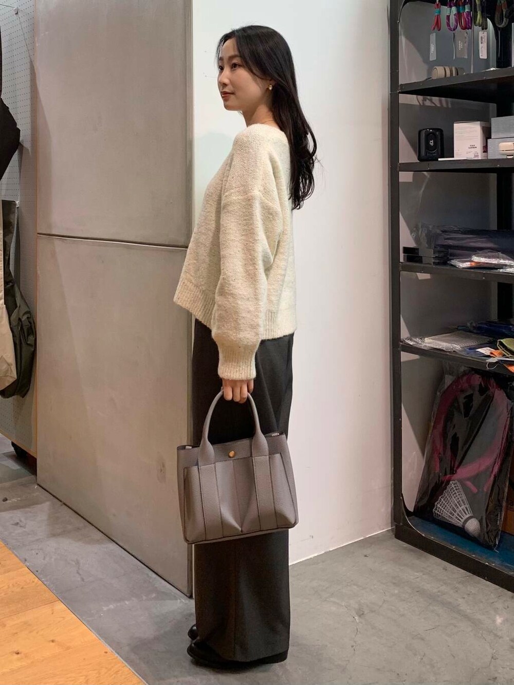 ブラック系のブーツ、グレー系のトートバッグ、ホワイト系のニット/セーターを着用したレディースの冬コーディネートの6枚目の写真