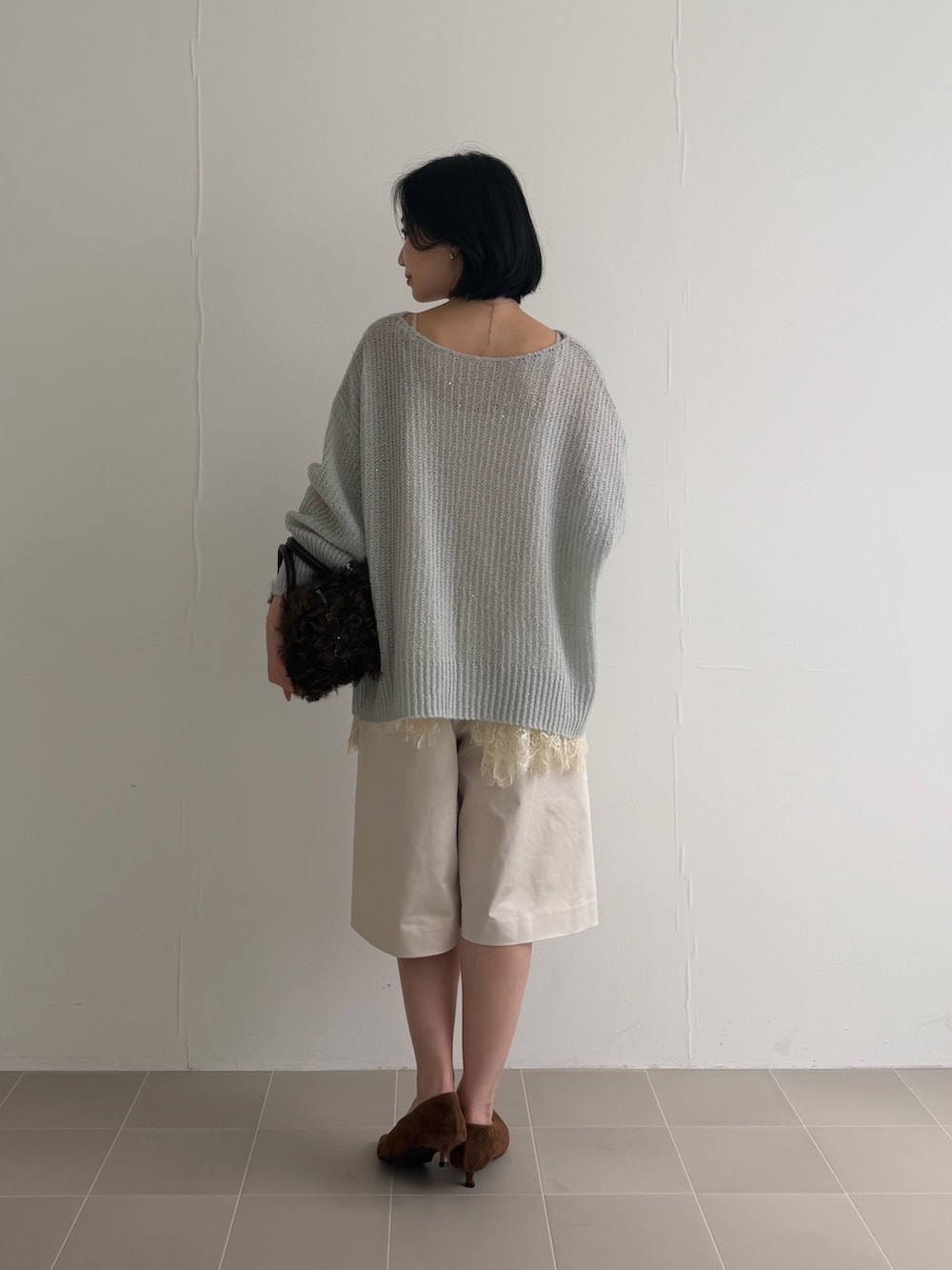 グリーン系のニット/セーター、ホワイト系のキャミソール、ホワイト系のその他パンツを着用したレディースの夏コーディネートの5枚目の写真