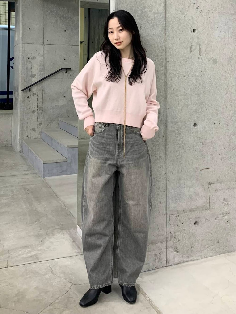 ブラック系のブーツ、グリーン系のデニムパンツ、ピンク系のニット/セーターを着用したレディースの冬コーディネートの2枚目の写真