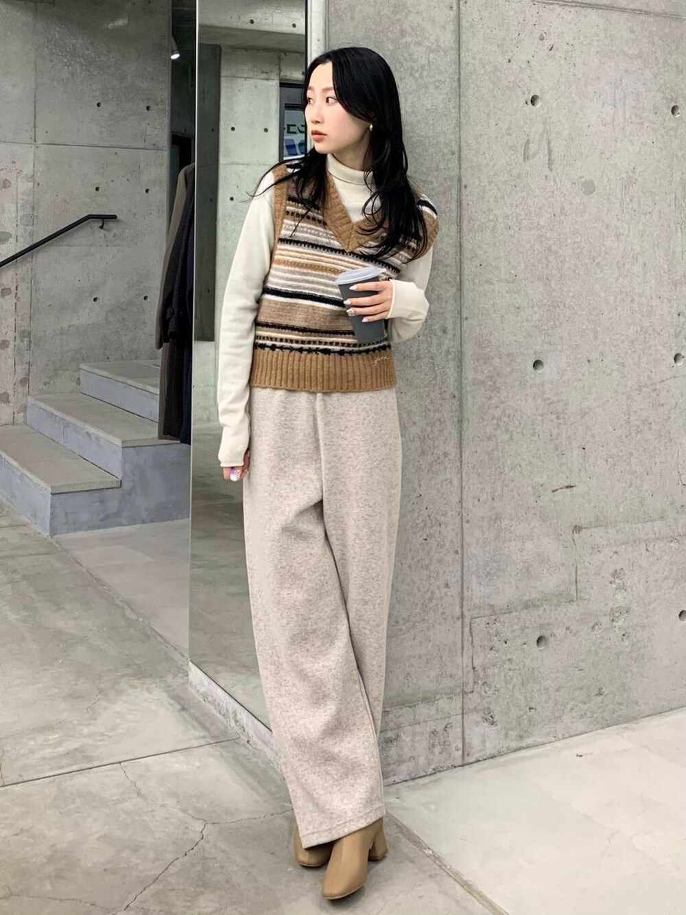 ベージュ系のブーツ、ブラウン系のベスト、ベージュ系のその他パンツを着用したレディースの冬コーディネートの4枚目の写真