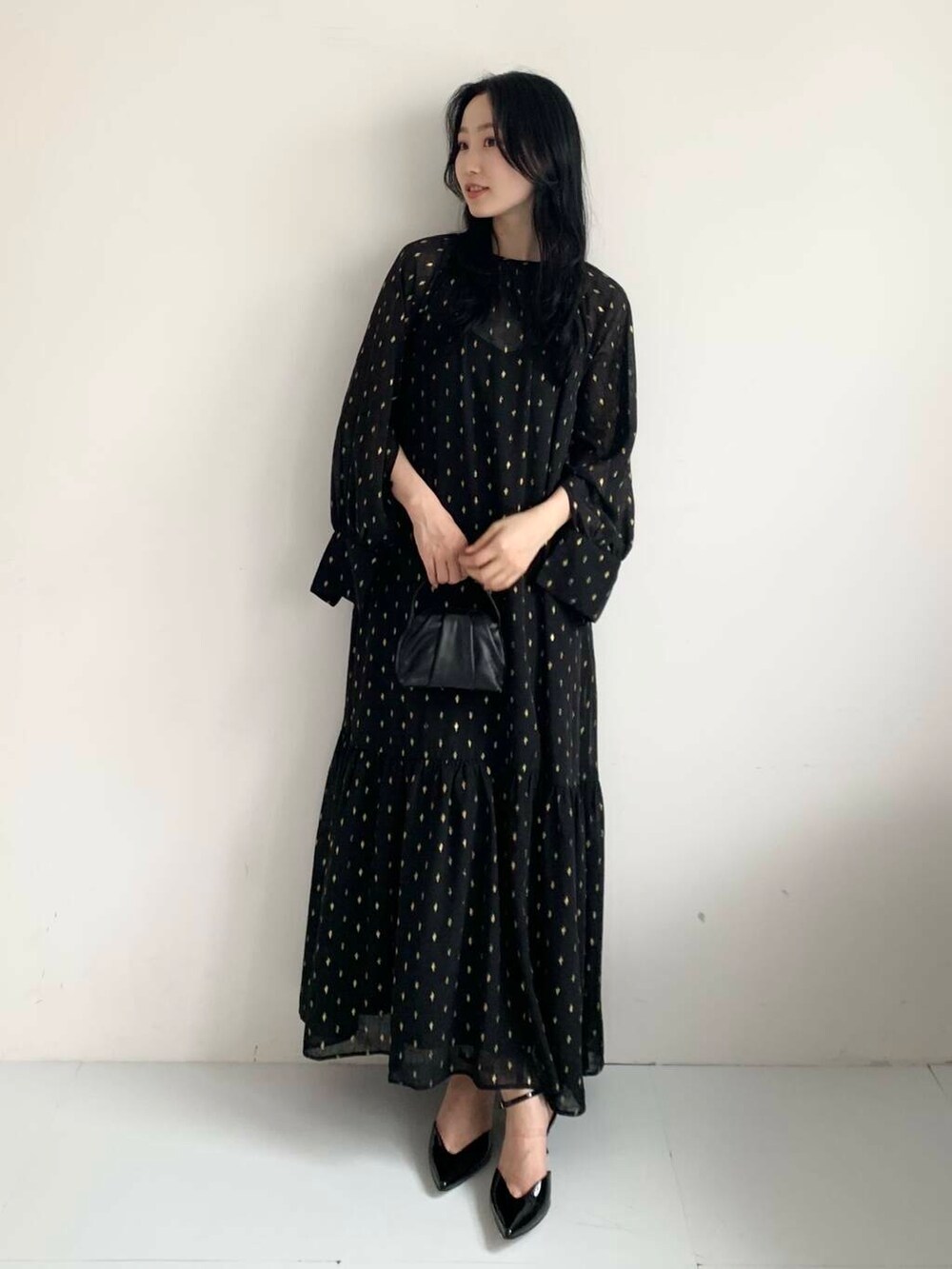 ブラック系のハンドバッグ、ブラック系のワンピースを着用したレディースの夏コーディネートの2枚目の写真