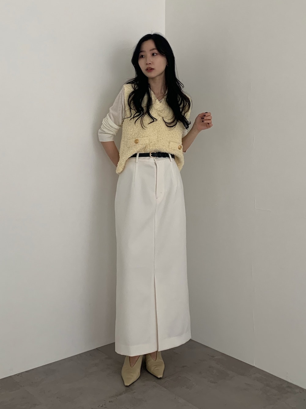 イエロー系のベストを着用したレディースの冬コーディネートの2枚目の写真