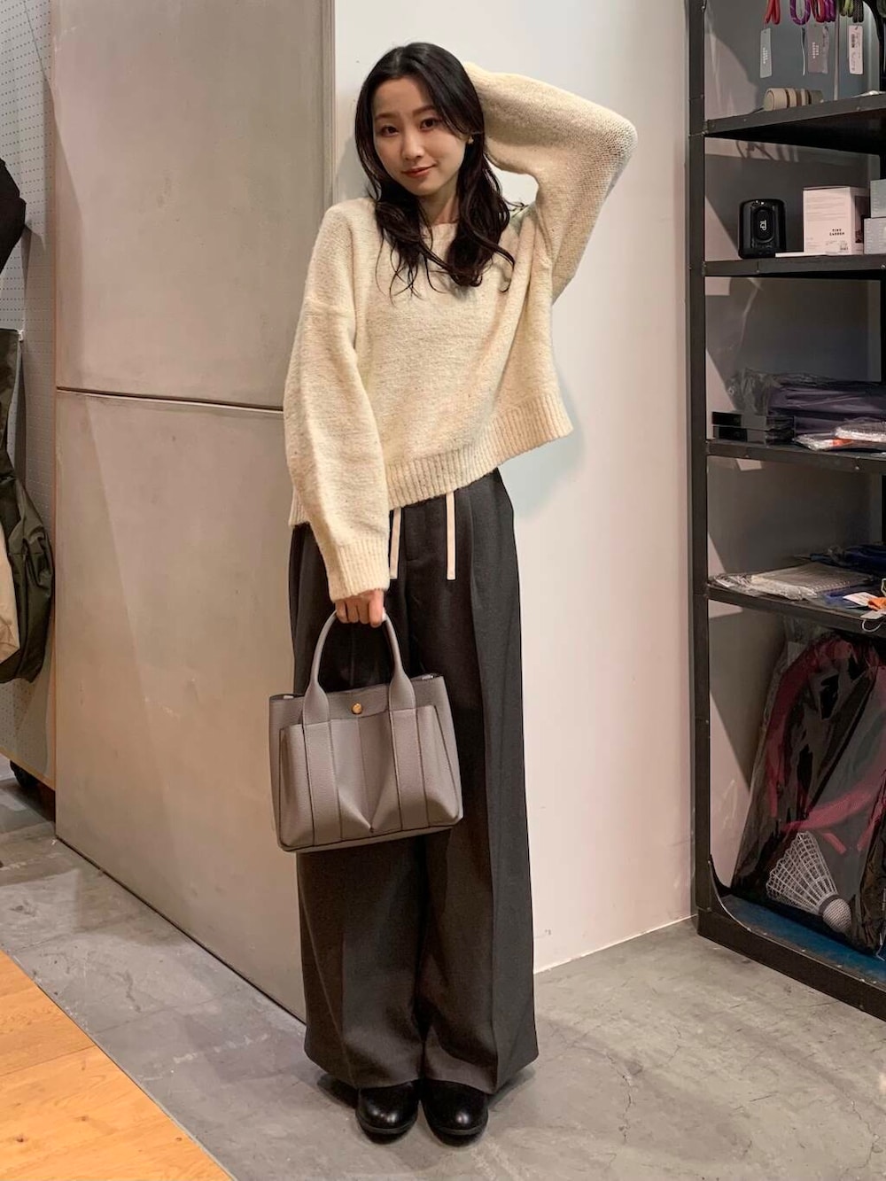 ブラック系のブーツ、グレー系のトートバッグ、ホワイト系のニット/セーターを着用したレディースの冬コーディネートの4枚目の写真