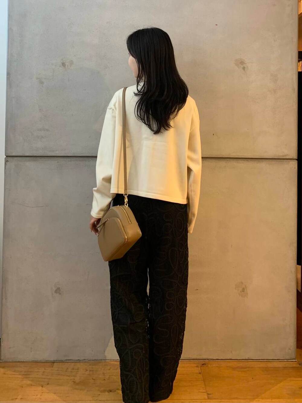 ベージュ系のショルダーバッグ、ホワイト系のカーディガン/ボレロ、ブラック系のブーツを着用したレディースの秋コーディネートの6枚目の写真