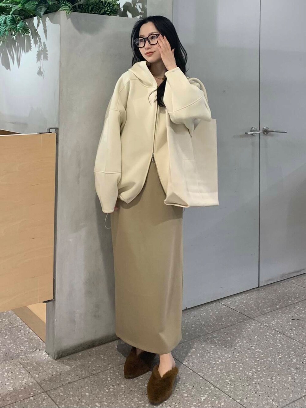 イエロー系のその他シューズ、ベージュ系のスカート、ホワイト系のパーカーを着用したレディースの冬コーディネートの2枚目の写真