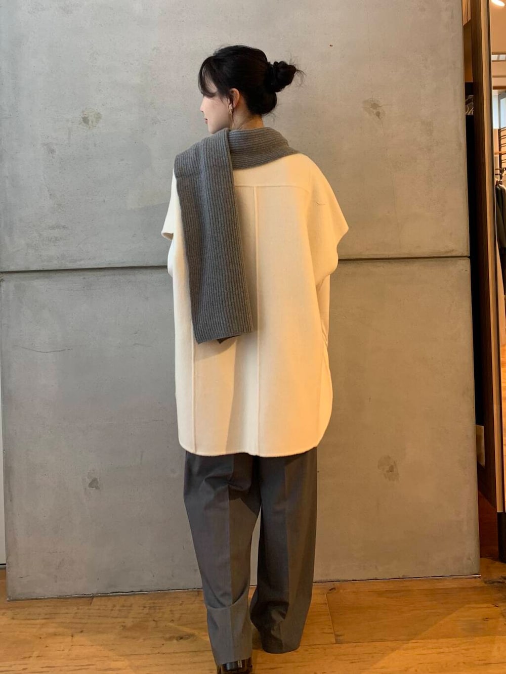 グレー系のその他パンツ、ホワイト系のポンチョ、ブラック系のレインシューズを着用したレディースの秋コーディネートの6枚目の写真