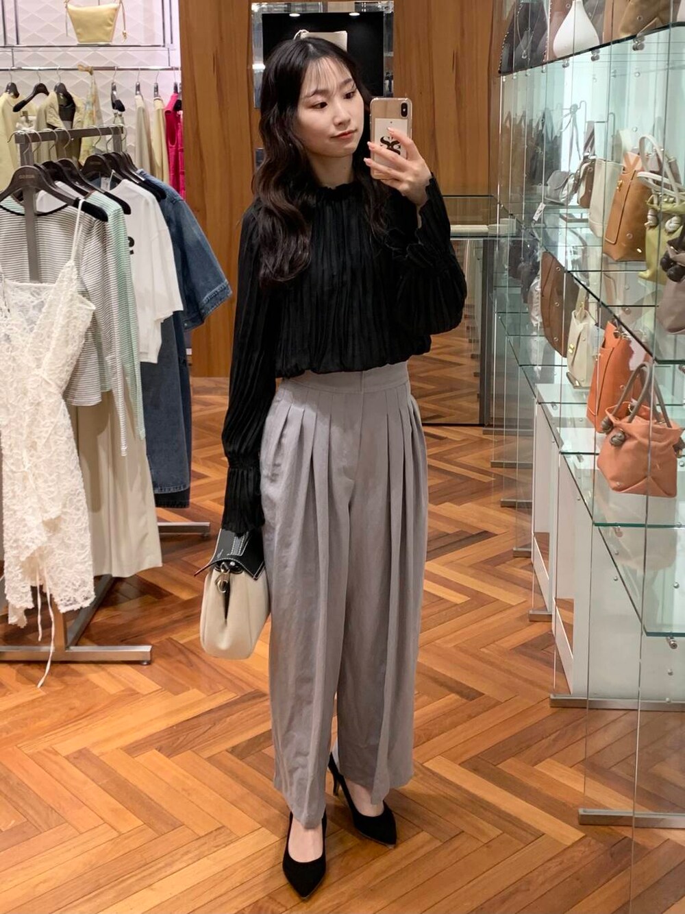 ブラック系のパンプス、グレー系のその他パンツ、ブラック系のシャツ/ブラウスを着用したレディースの春コーディネートの3枚目の写真