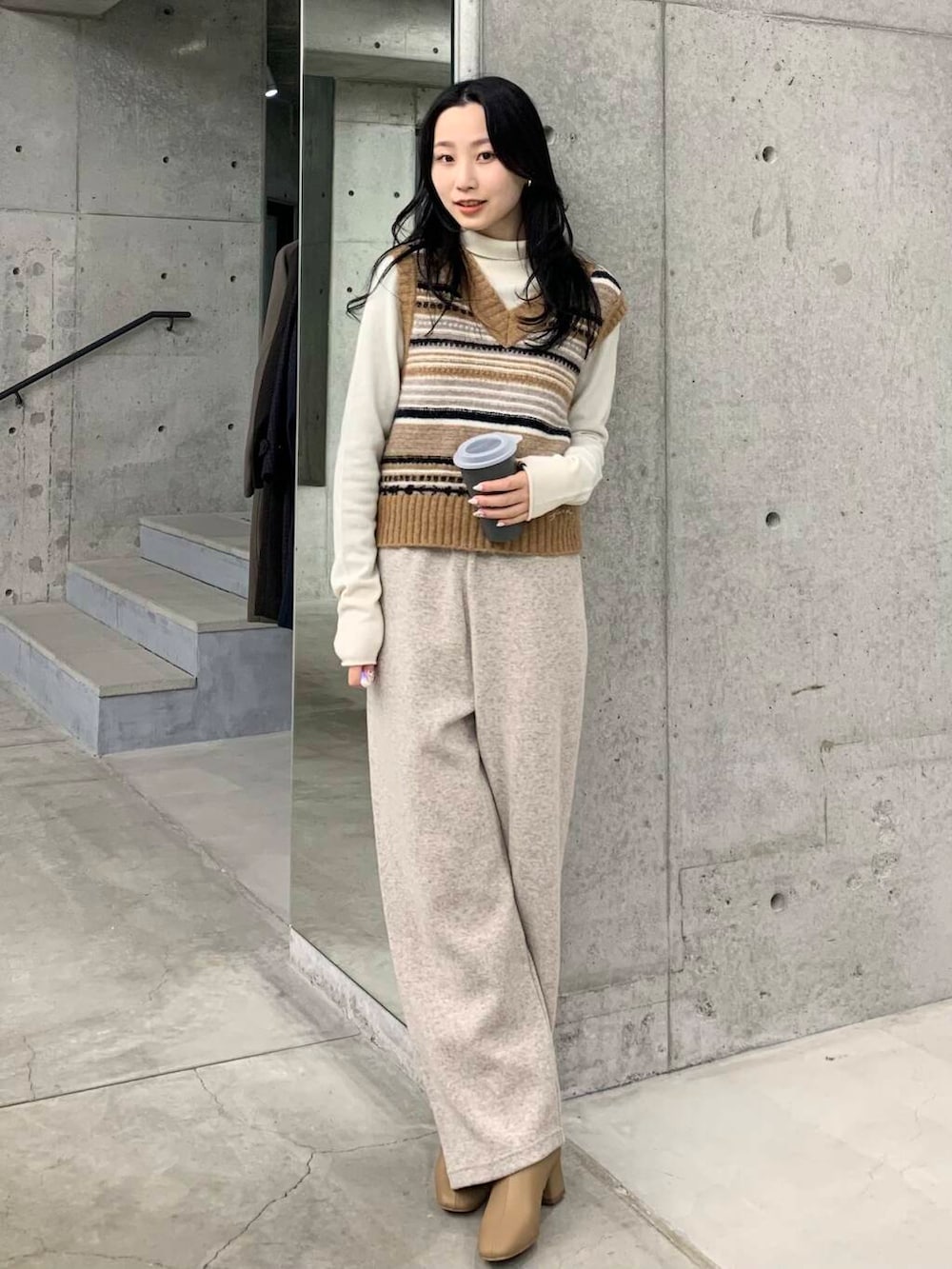 ベージュ系のブーツ、ブラウン系のベスト、ベージュ系のその他パンツを着用したレディースの冬コーディネートの2枚目の写真