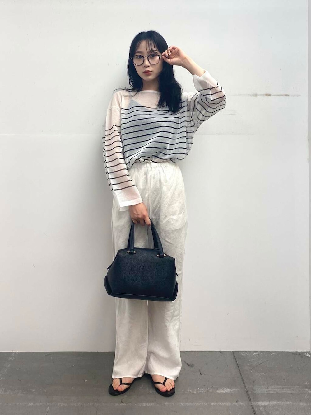ブラック系のサンダル、ブラック系のハンドバッグ、ホワイト系のその他パンツを着用したレディースの夏コーディネートの3枚目の写真