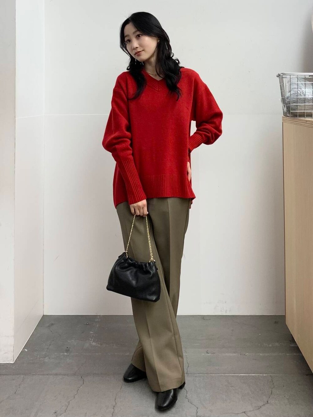 ブラック系のブーツ、レッド系のニット/セーター、ベージュ系のその他パンツを着用したレディースの冬コーディネートの7枚目の写真