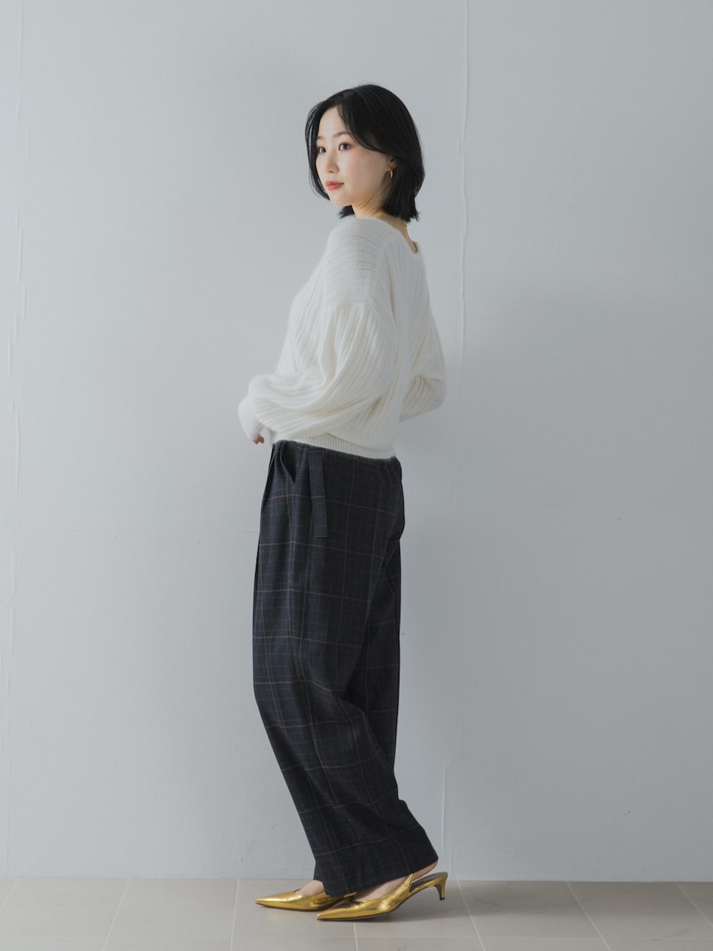 ホワイト系のニット/セーター、ブルー系のその他パンツ、ゴールド系のパンプスを着用したレディースの夏コーディネートの3枚目の写真